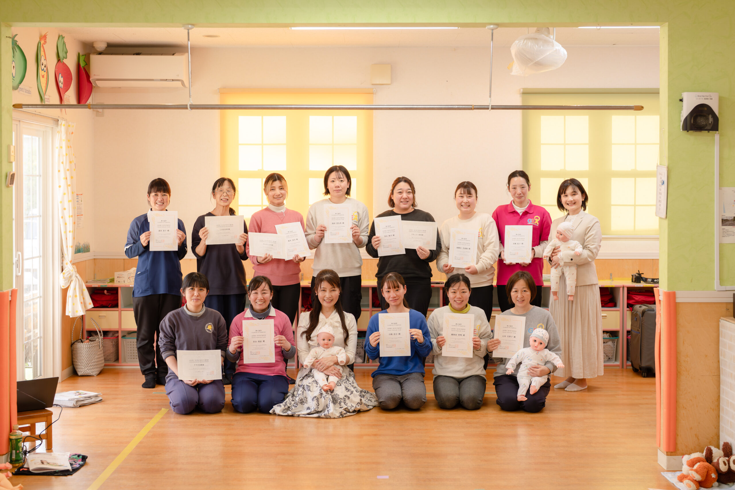 認定証を手にするふれあい なでなであそびの認定者の皆さん